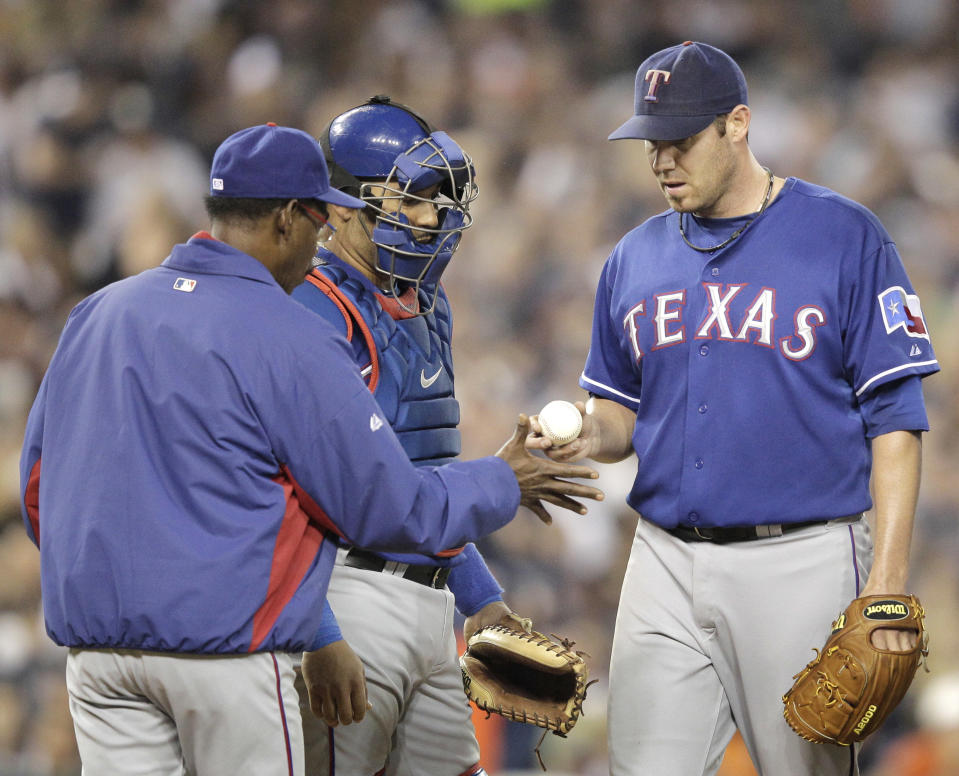 Texas Rangers manager Ron Washington takes the ball from starting pitcher Colby Lewis during the sixth innning of Game 3 of baseball's American League championship series against the Detroit Tigers, Tuesday, Oct. 11, 2011, in Detroit. (AP Photo/Charlie Riedel)