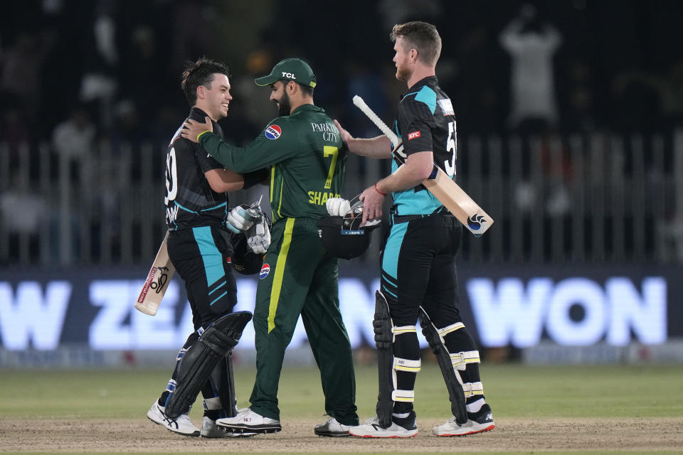 New Zealand's Mark Chapman, left, and James Neesham, right, shake hand with Pakistan's Shadab Khan on the end of play of the third T20 international cricket match between Pakistan and New Zealand, in Rawalpindi, Pakistan, Sunday, April 21, 2024. (AP Photo/Anjum Naveed)