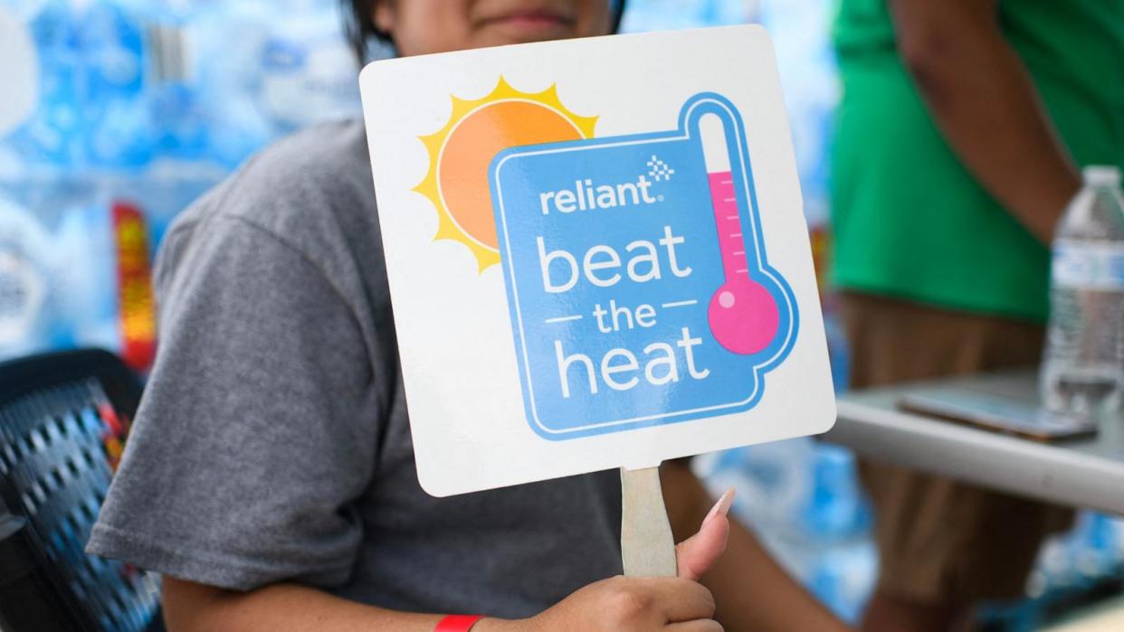 PHOTO: A woman holds up a fan in Houston, July 11, 2024.  (Mark Felix/AFP via Getty Images)