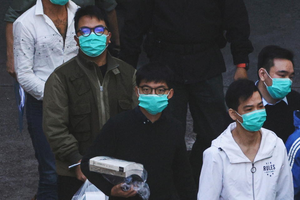 Pro-democracy activists Ivan Lam and Joshua Wong walk to a prison van to the court, after pleading guilty to charges of organising and inciting an unauthorised assembly near the police headquarters during last year's anti-government protests, in Hong Kong, China December 2, 2020. REUTERS/Tyrone Siu