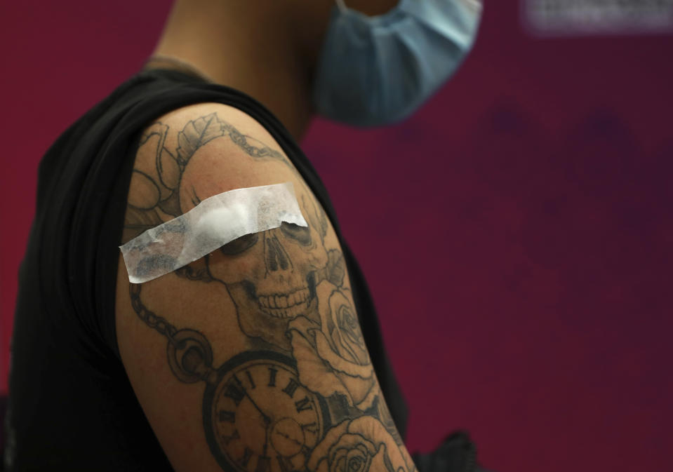 Jade Fisher, 22, has a bandage on his arm while he waits in the observation area after receiving a first dose of the Pfizer COVID-19 vaccine at the Vaccination Centre of Hope at the Cape Town International Convention Centre in Cape Town, South Africa, Tuesday Aug. 24, 2021. A survey of people aged 18-24 in 15 African countries found that many have lost jobs or have seen their education disrupted by the pandemic. (AP Photo/Nardus Engelbrecht)