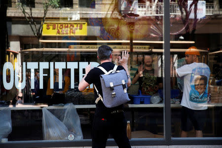 A man gestures to workers inside a darkened Urban Outfitters during a major power outage in San Francisco, California, U.S., April 21, 2017. REUTERS/Stephen Lam