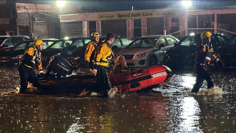 In this image provided by Pittsburgh Public Safety, Pittsburgh area water rescue team rescued a woman trapped in a car sinking in rising waters along a section of Route 51 east of the city Thursday night, April 11, 2024, in Pittsburg. Flash flooding caused by relentless heavy rains that soaked western Pennsylvania spurred numerous rescues and evacuations in the region, but no injuries were reported. (Pittsburgh Public Safety via AP)