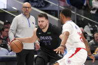 Dallas Mavericks guard Luka Doncic (77) tries to dribble past Los Angeles Clippers guard Norman Powell, right, as Mavericks' head coach Jason Kidd looks on during the second half of an NBA basketball first-round playoff series Friday, May 3, 2024, in Dallas. (AP Photo/Jeffrey McWhorter)
