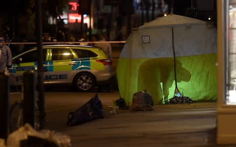 Police officers work inside a tent at the scene on Upper Street in Islington, north London - Credit: Victoria Jones/PA