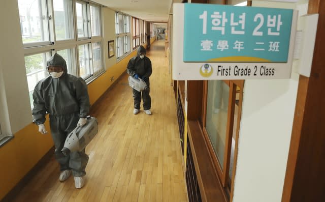 Workers disinfect as a precaution against the new coronavirus ahead of school reopening at an elementary school in Gwangju, South Korea