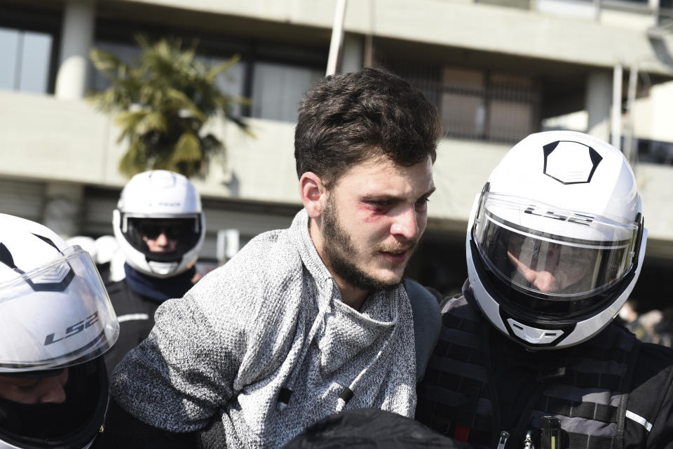 Police detain a protester at the University of Thessaloniki in northern Greece , on Monday, Feb. 22, 2021. Police clashed with protesters and detained more than 30 people in Greece's second-largest city Monday during a demonstration against a new campus security law. (AP Photo/Giannis Papanikos)