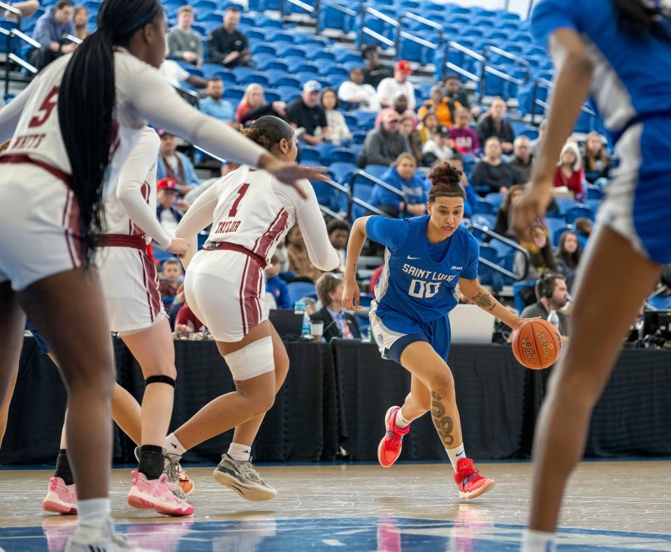 Saint Louis' Kyla McMakin (00) dribbles the ball past Massachusetts' Sydney Taylor (1) during the first half of an NCAA college basketball championship game in the Atlantic 10 Conference Tournament, Sunday, March 5, 2023, in Wilmington, Del. (AP Photo/Jason Minto)