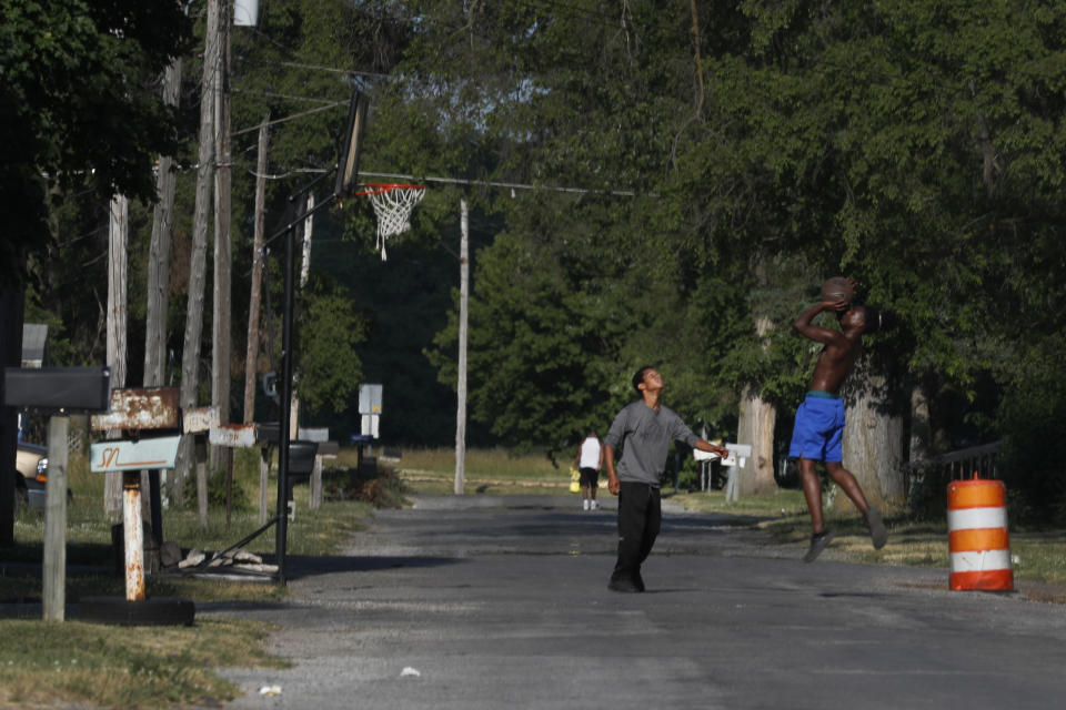 Youths play a game of one-on-one basketball Monday, June 29, 2020, on a neighborhood street on the impoverished east side of Saginaw, Mich. Saginaw has battled crime, inadequate educational options and food deserts that have largely impacted the city’s Black and Latino residents. (AP Photo/Charles Rex Arbogast)