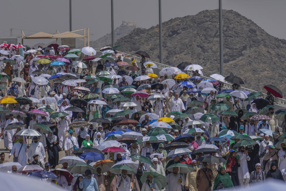 Peregrinos musulmanes usan sombrillas para protegerse del sol para arrojar piedras contra varias columnas en la lapidación simbólica del diablo, el último rito del haj anual, en Mina, cerca de la ciudad sagrada de La Meca, Arabia Saudí, el martes 18 de junio de 2024. (AP Foto/Rafiq Maqbool)