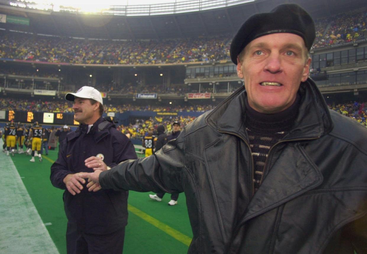 Pro Football Hall of Fame linebacker Jack Lambert, right, greets Steelers coach Bill Cowher, left, before a game against Washington, Saturday, Dec. 16, 2000, in Pittsburgh — the last game in the history of Three Rivers Stadium.