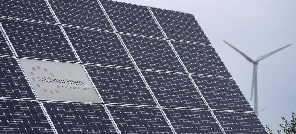 The logo of the 'Feldheim Energie' (Feldheim Energy) company is framed by solar panels in Feldheim near Treuenbrietzen, Germany, Wednesday, Sept. 28, 2022. Located about an hour and a half south of Berlin, the village of Feldheim has been energy self-sufficient for more than a decade. (AP Photo/Michael Sohn)