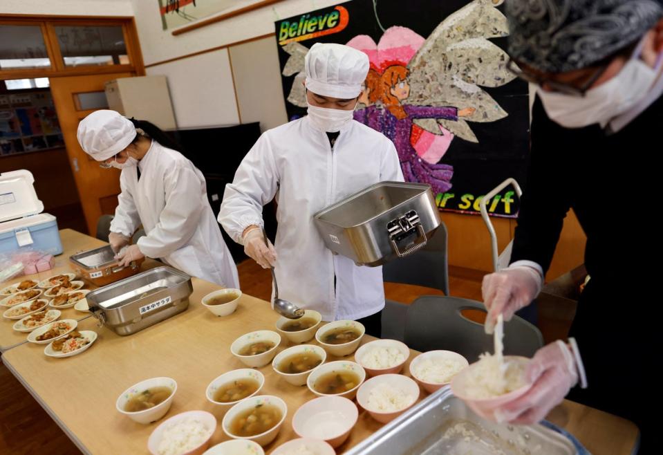 Plenty to go around... being served their last school lunch (Reuters)