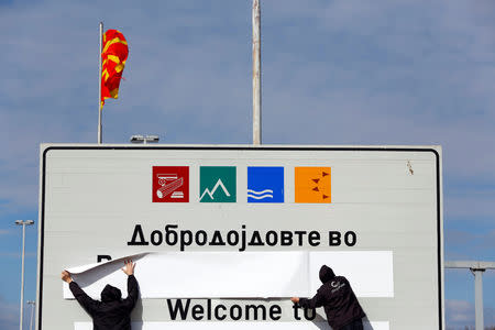 Workers cover a sign of the Republic of Macedonia at the border between Macedonia and Greece, near Gevgelija, Macedonia February 13, 2019. REUTERS/Ognen Teofilovski