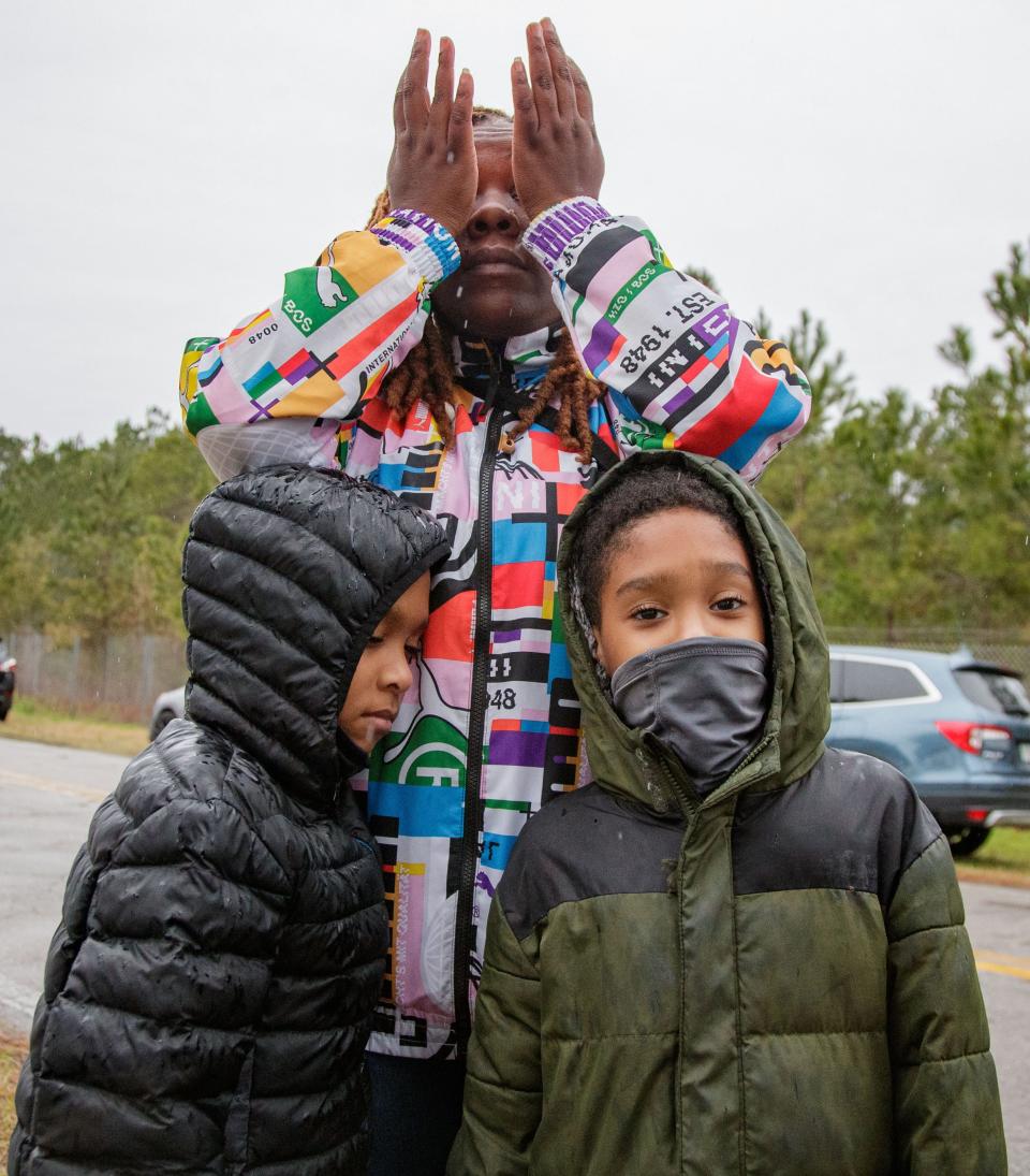 Twin brothers Terrance and Douglas Johnson, 8, stand with their mother LeChaye Johnson as she wipes tears from her eyes while sharing the struggles she has been experiencing with finding new housing after the mobile home park she lived in was bought out and the rent prices were severely increased Tuesday, Jan. 25, 2022.