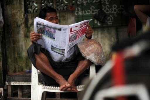 A man reads a local journal in Yangon in August. Myanmar's state newspapers signalled a historic change in focus on Saturday, announcing a plan to transform into "public service media"