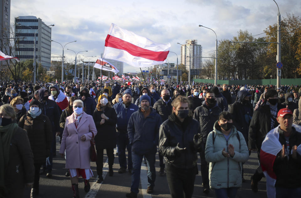 People with old Belarusian national flags march during an opposition rally to protest the official presidential election results in Minsk, Belarus, Sunday, Oct. 18, 2020. Tens of thousands rallied in Minsk once again on Sunday, demanding the resignation of the country's authoritarian leader. Mass weekend protests in the Belarusian capital have continued since Aug. 9, when officials handed President Alexander Lukashenko a landslide victory in an election widely seen as rigged. (AP Photo)