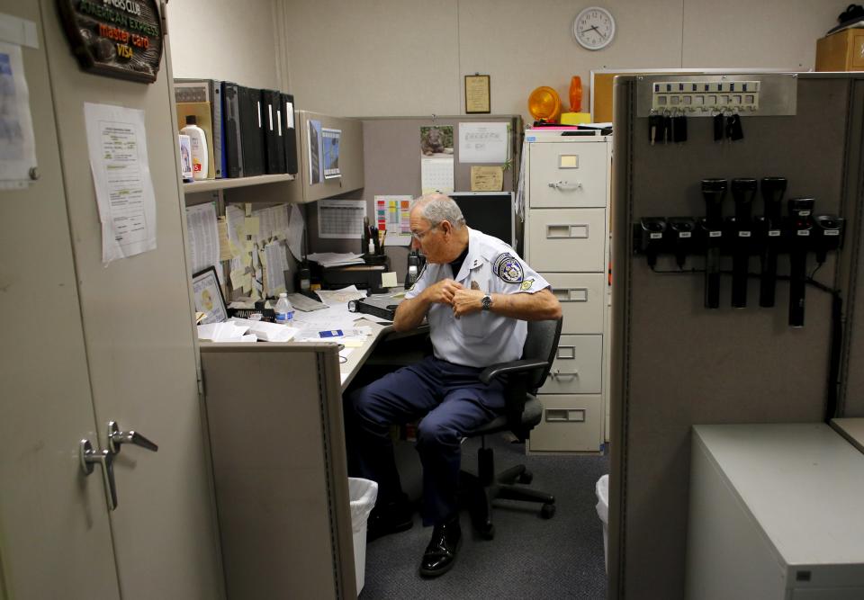 Robert Stewart, Retired Senior Volunteer Patrol administrator, works at his desk in the San Diego Police traffic office in San Diego, California, United States February 4, 2015. (REUTERS/Mike Blake)