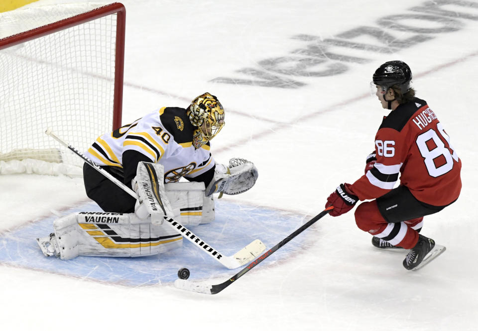 Boston Bruins goaltender Tuukka Rask (40) deflects a shot by New Jersey Devils center Jack Hughes (86) during the shootout of an NHL hockey game Thursday, Jan. 14, 2021, in Newark, N.J. (AP Photo/Bill Kostroun)