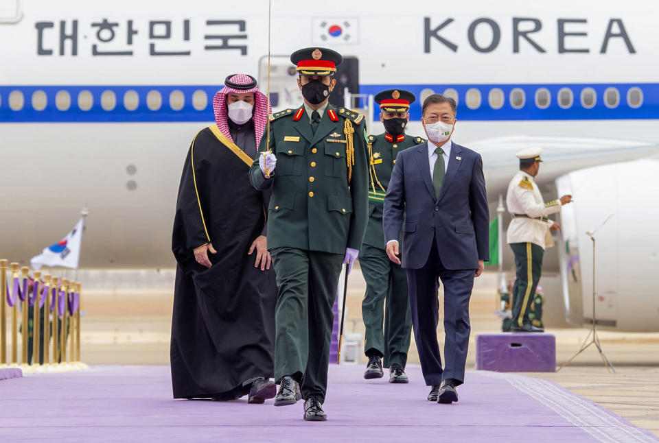 In this photo released by the Saudi Royal Palace, Saudi Crown Prince Mohammed bin Salman, right, accompanies South Korean President Moon Jae-in, at Riyadh's international airport, Saudi Arabia, Tuesday, Jan. 18, 2022. It is the latest visit by a head of state to Saudi Arabia as a growing number of world leaders resume bilateral meetings and trips abroad following COVID-19 vaccine rollouts in many parts of the world. (Bandar Aljaloud/Saudi Royal Palace via AP)