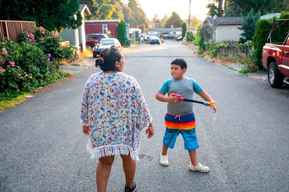 Saraim Nieto anda por la calle principal de Meridian Estates con su hijo, Sergio Calderón, el miércoles 27 de julio de 2022 en Puyallup, Washington.
