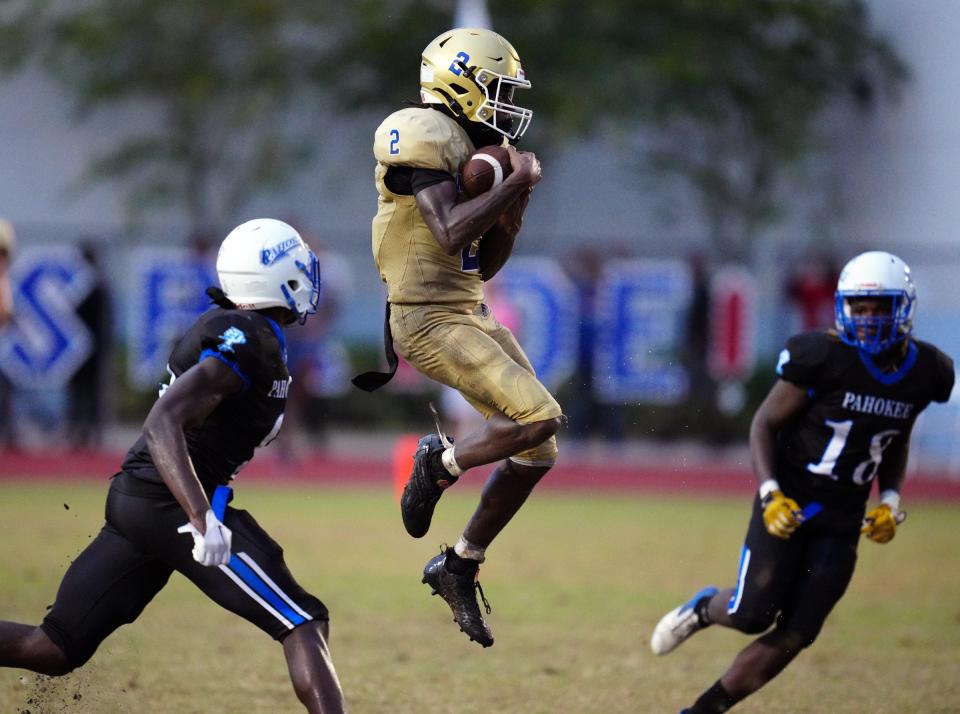 Josh Philostin (2) of Cardinal Newman (2) catches a pass over the middle as Pahokee's Bijay Boldin (9) closes in on the play on Thursday, August 25, 2022 in Pahokee.