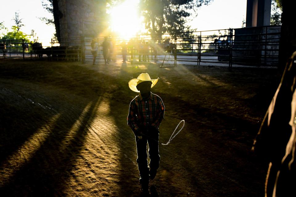 A young cowboy hangs out back stage at the Industry Hills Expo Center outdoor arena during the 35th annual Bill Pickett Rodeo on July 20, 2019 in City of Industry, California.