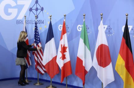 FILE PHOTO: An official adjusts flags during the G7 summit at the European Council building in Brussels June 5, 2014.    REUTERS/Francois Lenoir