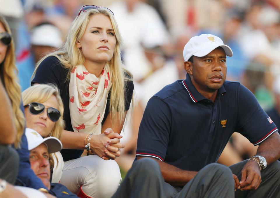 U.S. golfer Tiger Woods and girlfriend Lindsey Vonn sit with teammate Phil Mickelson and Phil's wife Amy (L) as they watch play during the opening Four-ball matches for the 2013 Presidents Cup golf tournament at Muirfield Village Golf Club in Dublin, Ohio October 3, 2013. REUTERS/Chris Keane (UNITED STATES - Tags: SPORT GOLF)