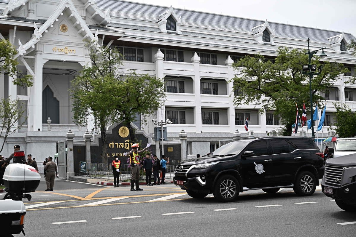 A police car (right) believed to be carrying Shinawatra leaves Thailand’s Supreme Court (AFP/Getty)