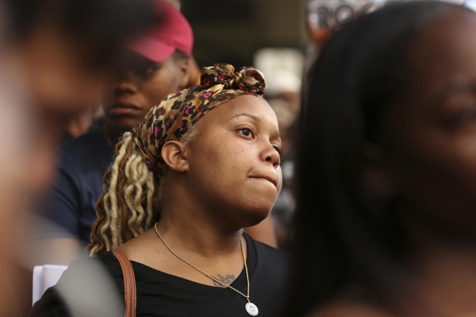 Malika Harris, 25, listens to speakers at a vigil held on Monday, July 23, 2018, for her sister, 18-year-old Nia Wilson, who was stabbed to death the day before at the Bay Area Rapid Transit's MacArthur Station in Oakland, Calif. "I feel like she was just in the wrong place at the wrong time," Harris said. (AP Photo/Lorin Eleni Gill)