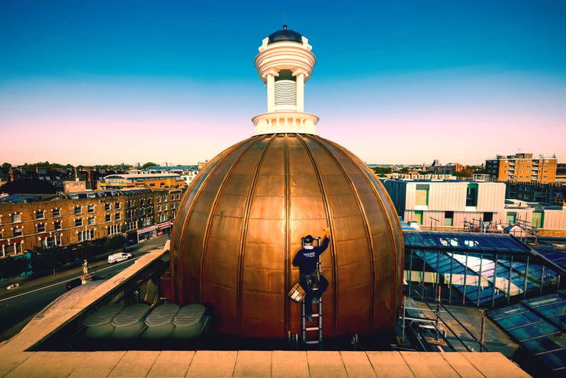 A person works at the newly restored dome of the Koko Theater, in London