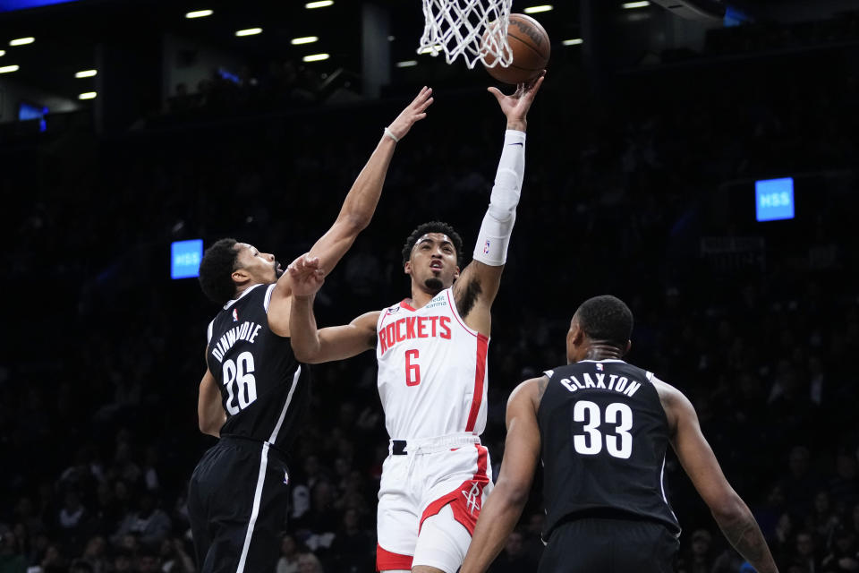 Houston Rockets' Kenyon Martin Jr. (6) drives past Brooklyn Nets' Spencer Dinwiddie (26) as Nic Claxton (33) watches during the first half of an NBA basketball game Wednesday, March 29, 2023, in New York. (AP Photo/Frank Franklin II)