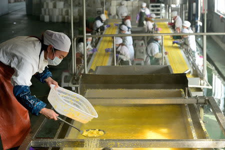 Employees work at a food processing factory in Yichang, Hubei province, January 17, 2016. REUTERS/Stringer