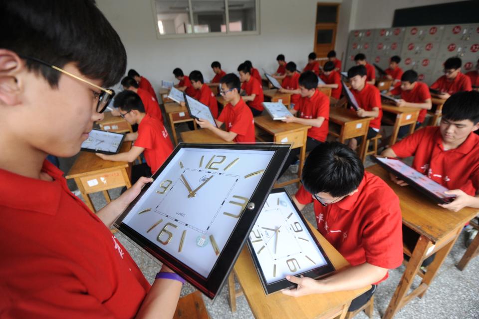 taff members calibrate clocks ahead of China's annual National College Entrance Exam, also known as "Gaokao", at a high school in Qingdao, Shandong province, China, June 5, 2017.