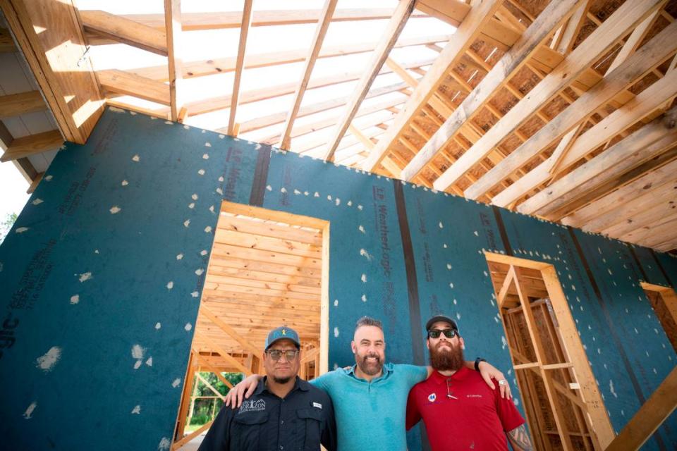 Mike Toribio, left, owner of New Horizon Roofing & Exteriors, along with estimator Samuel White, right, are building a roof that can withstand winds of more than 200 mph for Josh Morgerman, center, who is building a house in Old Town Bay St. Louis. Morgerman is a well-known storm chaser who goes by iCyclone online. Justin Mitchell/Sun Herald