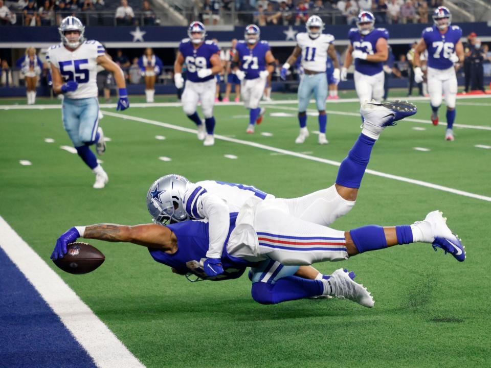 Devontae Booker reaches for the end zone against the Dallas Cowboys.