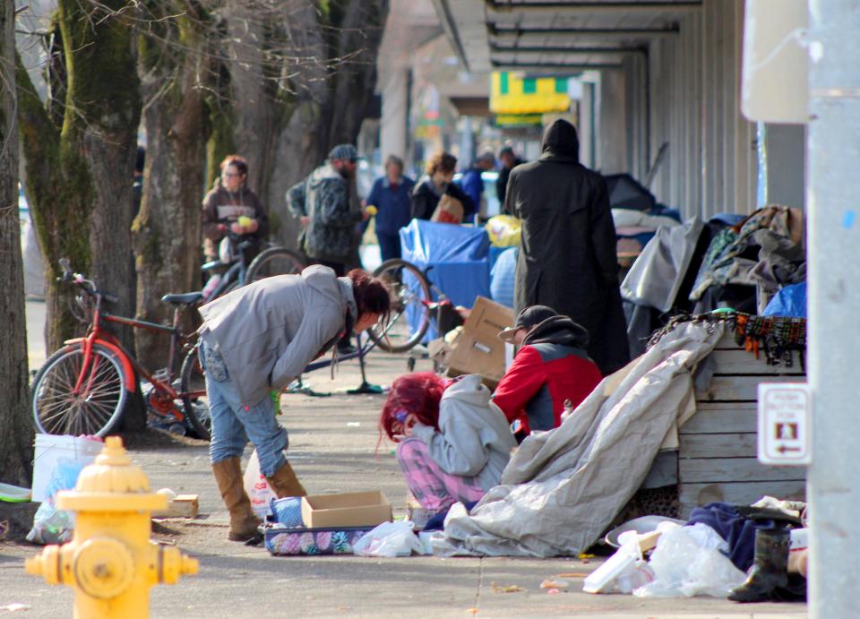 Homeless people crowd a sidewalk in downtown Salem, Ore., where they have set up a makeshift camp. Experts say that the homeless, who often have health and substance-abuse problems, are exposed to the elements and do not have easy access to hygiene, are more vulnerable to the coronavirus.