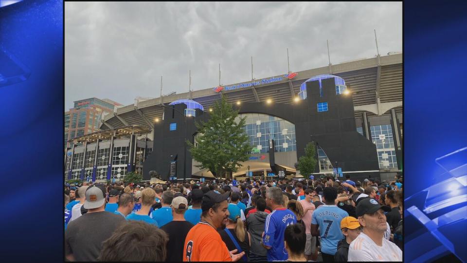 Charlotte FC fans wait outside Bank of America Stadium Wednesday night before the match. Lightning in the area delayed their entrance and kickoff.