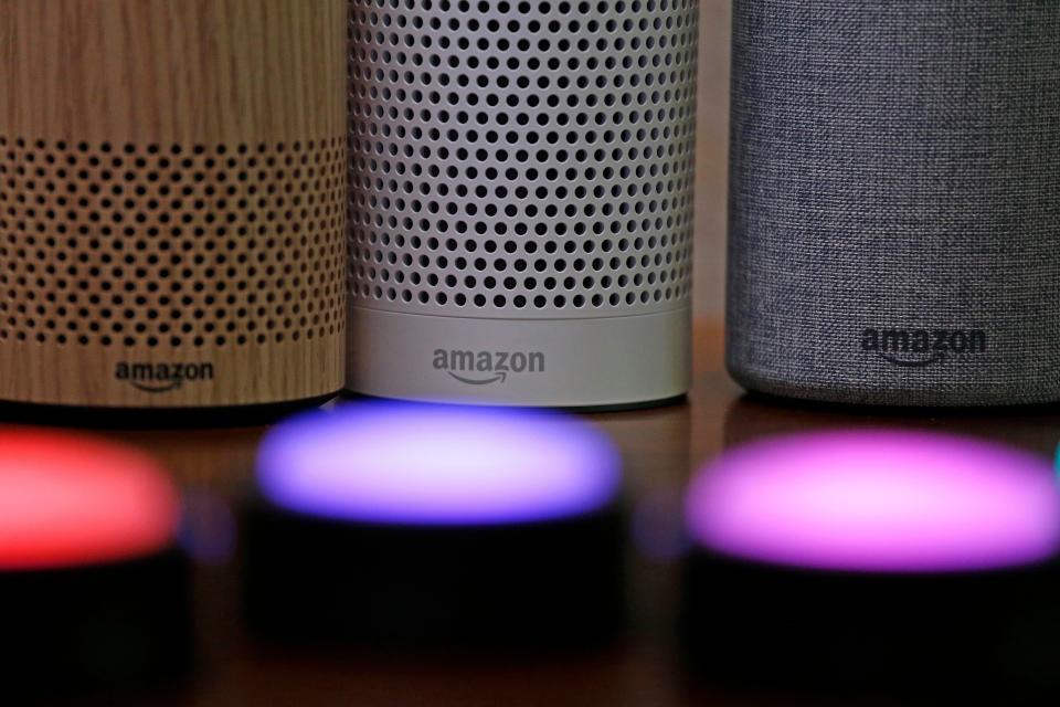 FILE - Amazon Echo and Echo Plus devices, behind, sit near illuminated Echo Button devices, Sept. 27, 2017, during an event announcing several new Amazon products by the company in Seattle. On Wednesday, Sept. 20, 2023, Amazon unveiled a slew of gadgets and an update to its popular voice assistant Alexa, infusing it with more generative AI features to better compete with other tech companies who've rolled out flashy chatbots. (AP Photo/Elaine Thompson, File)