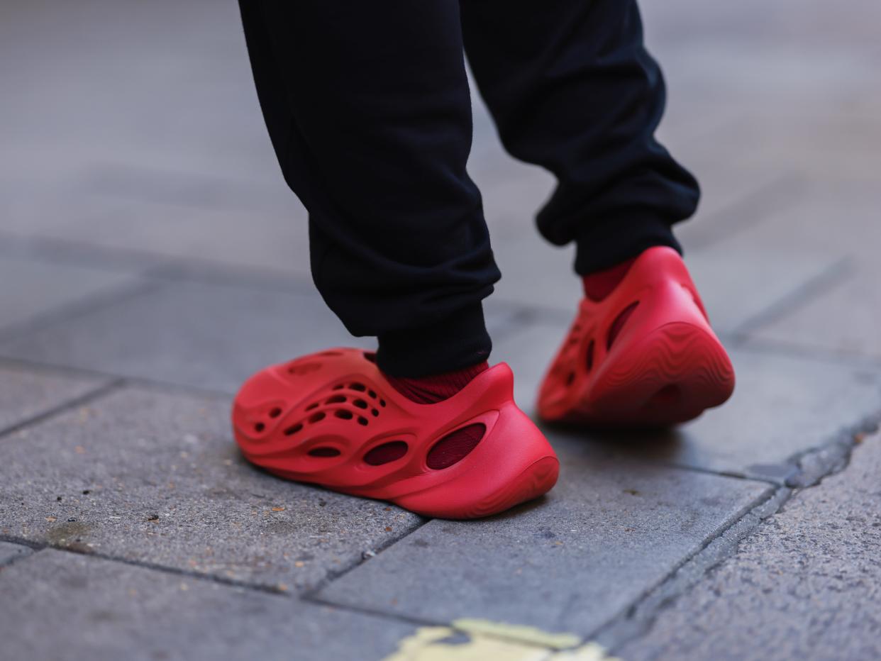 Feet wearing red Yeezy Adidas foam runner shoes