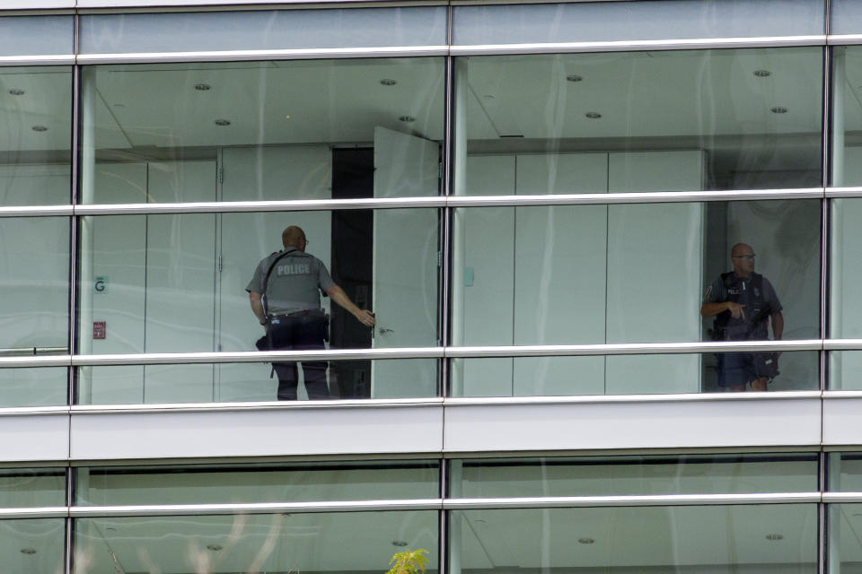 Law enforcement officers search one of the buildings that houses Gannett and USA Today, Wednesday, Aug. 7, 2019, in McLean, Va. (AP Photo/Alex Brandon)