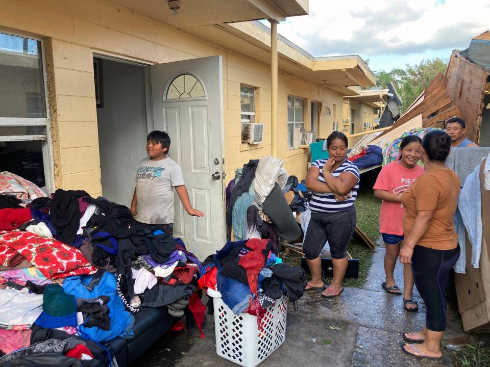 Residents of apartments in Harlem Heights, Fla., clean out clothes and other possessions from their apartments swamped by flood waters from Hurricane Ian, Saturday, Oct. 1, 2022.