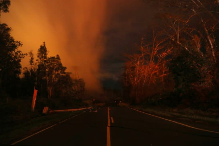 Lava illuminates volcanic gases (L) from the Kilauea volcano near fissure 13 on Hawaii's Big Island on May 16 -- the summit of the volcano erupted on Thursday