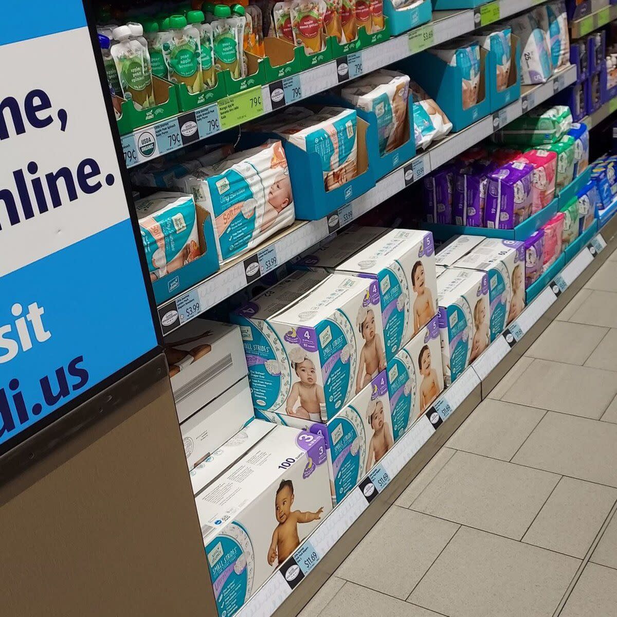 Diaper section at Aldi, Chandler, Arizona, two bottom rows filled with different kinds of diapers, top row with baby liquid food, clean floor