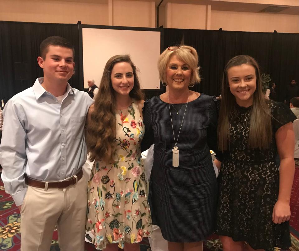 One of Patti Bounds' favorite parts of being a school board member is being able to see students she taught in kindergarten graduate from high school. Here, she shares a moment with former students (from left) Andy Cofer, Emma Cummings and Beth Karns.