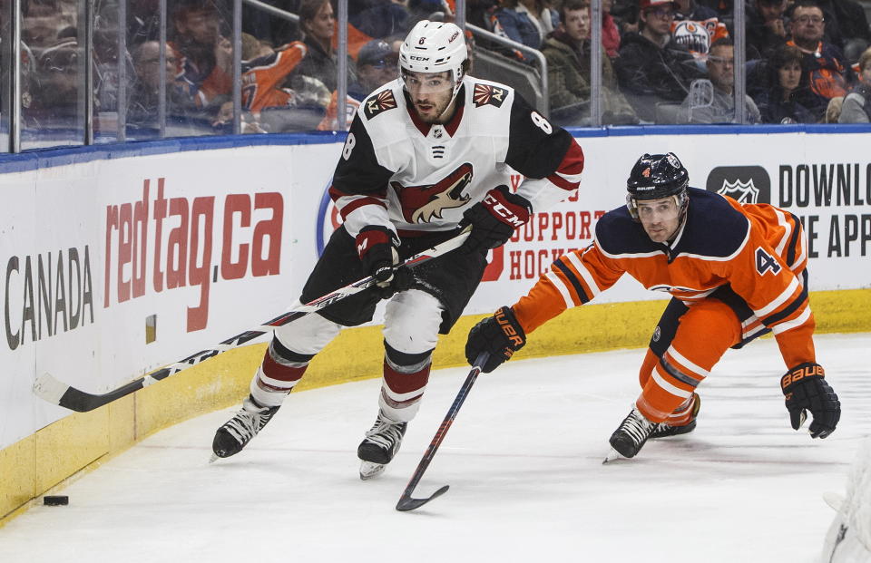Arizona Coyotes' Nick Schmaltz (8) is chased by Edmonton Oilers' Kris Russell (4) during third period NHL action in Edmonton, Alberta, on Saturday, Jan. 18, 2020. (Jason Franson/The Canadian Press via AP)
