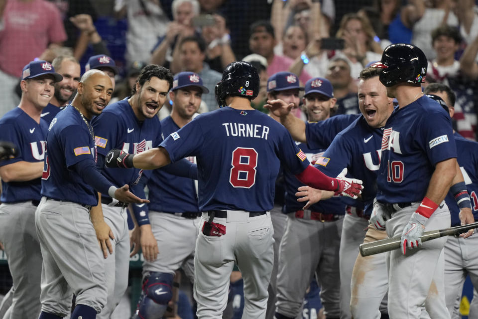 U.S.'s Trea Turner (8) is congratulated by the team after hitting a home run during the second inning at a World Baseball Classic final game against Japan, Tuesday, March 21, 2023, in Miami. (AP Photo/Marta Lavandier)