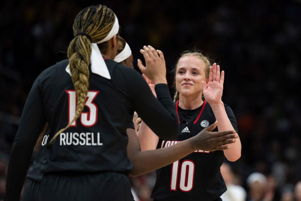 Louisville guard Hailey Van Lith (10) is congratulated by teammates Merissah Russell (13) and Olivia Cochran during the first half of an Elite 8 college basketball game against Iowa in the NCAA Tournament, Sunday, March 26, 2023, in Seattle. (AP Photo/Stephen Brashear)