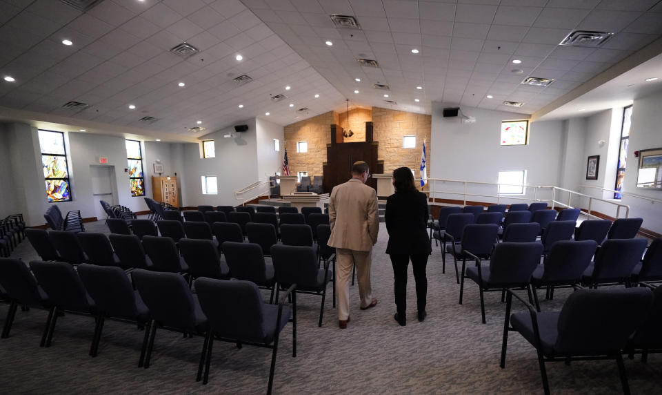 CORRECTS SPELLING OF LAST NAME TO EISEN, NOT EISENAT - Rabbi Charlie Cytron-Walker, left, and Anna Salton Eisen walk in Congregation Beth Israel in Colleyville, Texas, Thursday, April 7, 2022. Three months after an armed captor took hostages at the synagogue during a 10-hour standoff that ended with the escape of the hostages and fatal shooting of the gunman by the FBI, the house of worship is reopening. (AP Photo/LM Otero)